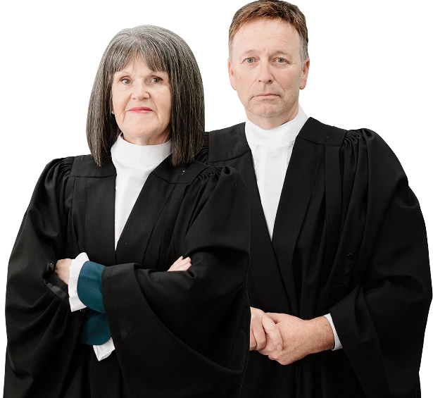 Two senior attorneys in traditional black legal robes standing side by side with confident expressions.